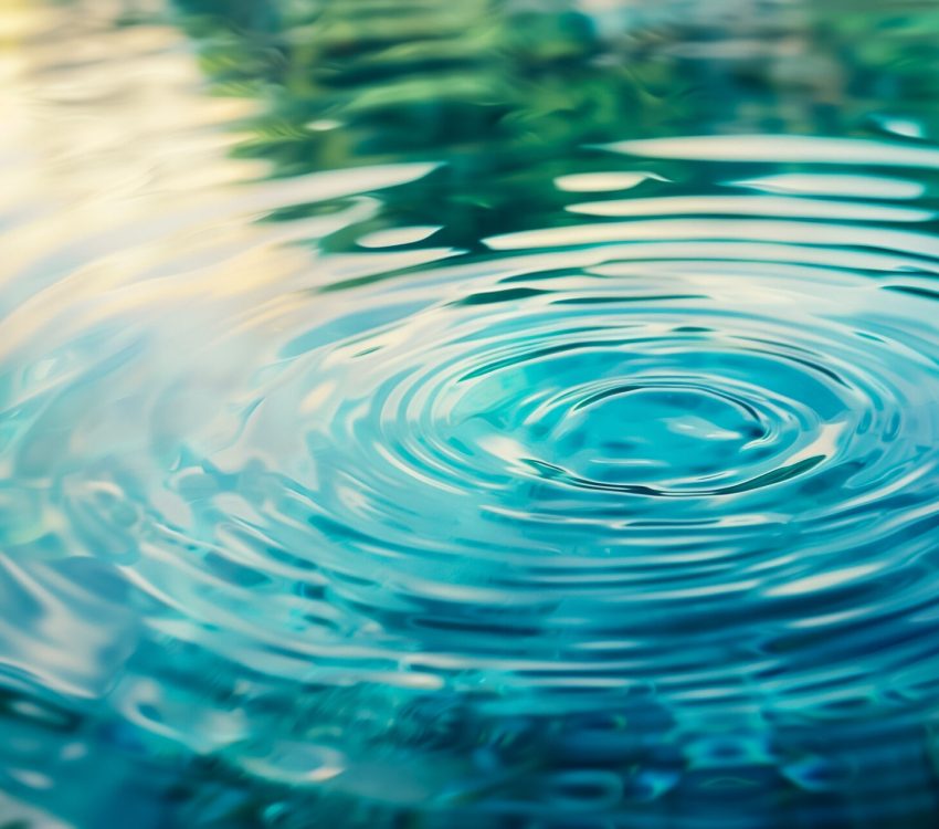 Serene water surface with concentric ripples and vibrant reflections, representing calmness, mindfulness, or the concept of impact and change; ideal for environmental or philosophical themes